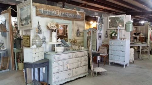 A vintage-style shop interior featuring rustic furniture, decor, and a cozy, inviting atmosphere.