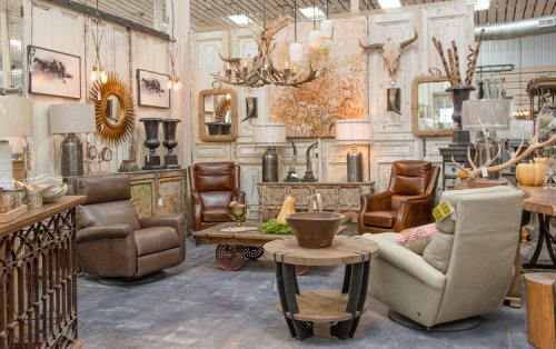 A cozy interior featuring stylish furniture, including leather chairs, a wooden table, and decorative wall art.
