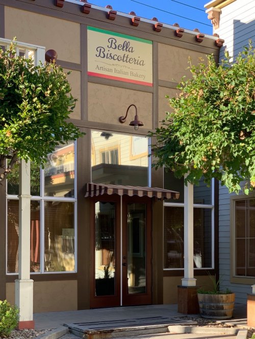 Exterior of Bella Biscotteria, an artisan Italian bakery, featuring a welcoming entrance and decorative awning.