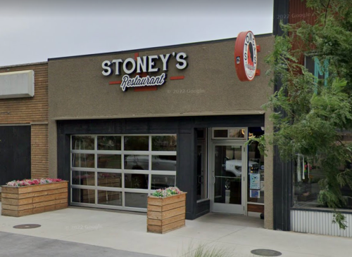 Exterior of Stoney's Restaurant featuring a modern design with large glass doors and planters.