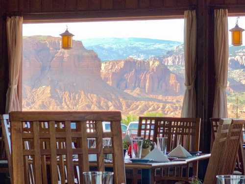 View from a restaurant window showcasing a scenic landscape of mountains and cliffs under a clear sky.