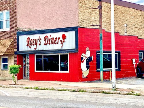 A red diner building with a sign reading "Rosy's Diner" and a cartoon chef painted on the wall.