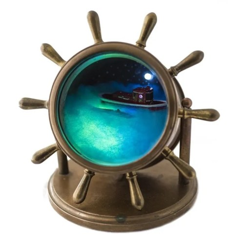 A decorative ship's wheel with a glass lens showing a miniature boat in a misty, illuminated scene.