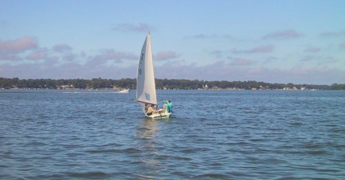 A sailboat scuds across the water under a blue sky in Clear Lake, Iowa.