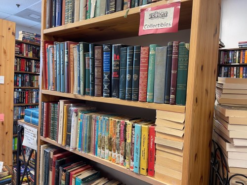 A wooden bookshelf filled with various books, labeled "Collectibles" at the top.