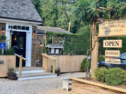 A cozy café entrance with a wooden sign reading "Open Tonight" and a menu featuring lamb chops.