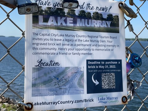 Sign inviting people to purchase engraved bricks at Lake Murray Dam, with a map and QR code for more information.