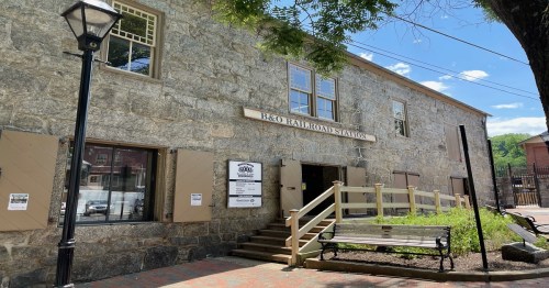 Exterior of the B&O Railroad Station, featuring stone walls, windows, and a wooden ramp, with a bench in front.