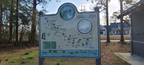 Map of a rail-to-trails project, showing trails, landmarks, and directions in a wooded area.