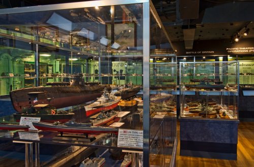 A display of detailed ship models in a museum, showcasing various naval vessels and historical exhibits.