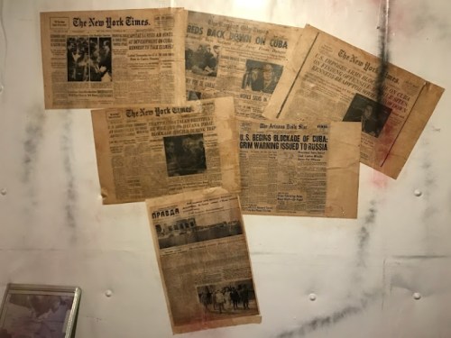A collage of vintage newspaper clippings on a wall, featuring headlines about Cuba and U.S.-Russia relations.