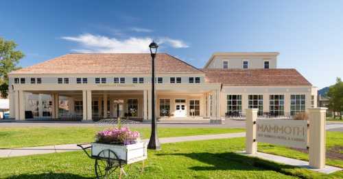 Exterior view of Mammoth Hot Springs Hotel, featuring a large building with a welcoming entrance and landscaped grounds.