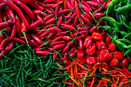 A vibrant assortment of red and green chili peppers arranged in a colorful display.