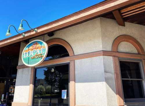 Exterior of a building featuring a sign that reads "LOCAL eatery" with a clear blue sky above.