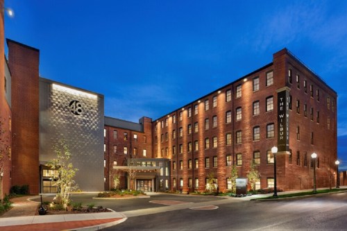 Exterior view of The Wilbur hotel at dusk, featuring brick architecture and modern design elements.