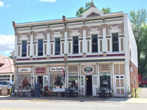 Historic building with colorful facade, featuring a café and antique shop, set against a clear blue sky.