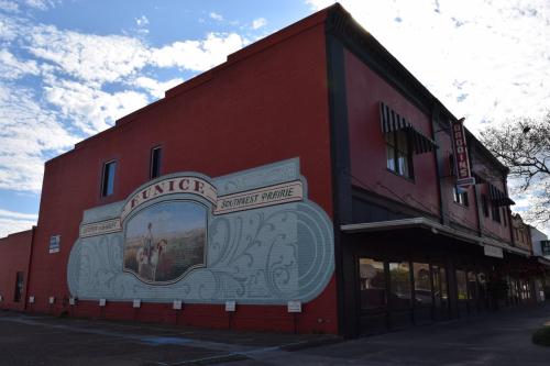 A red brick building with a mural depicting a historical scene and the text "Funice Southwest Prairie."