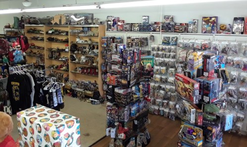 A toy store interior filled with shelves of action figures, collectibles, and merchandise, creating a vibrant shopping atmosphere.