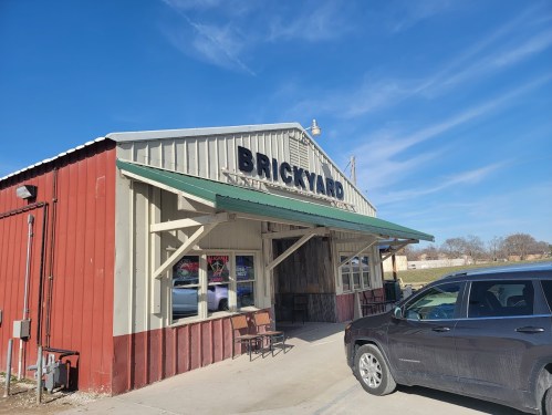 Exterior of a building labeled "Brickyard," featuring a red and gray facade, with a clear blue sky above.