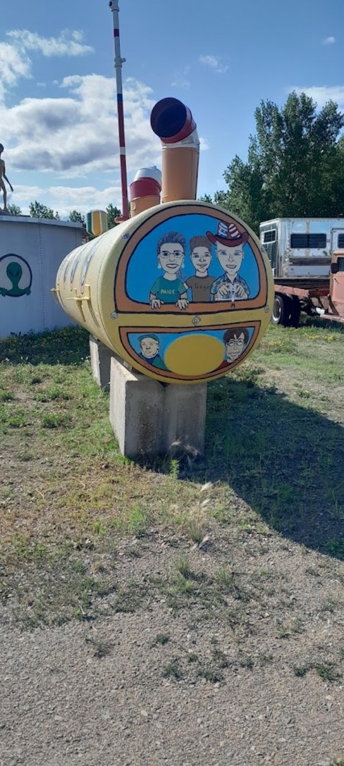 A colorful, painted tank featuring cartoon characters on a yellow background, set in a grassy area with blue skies.