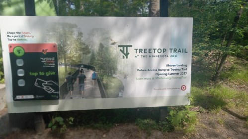 Sign for Treetop Trail at Minnesota Zoo, promoting future access ramp and donation information. Opening Summer 2023.