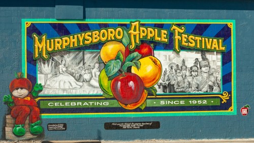 Colorful mural celebrating the Murphysboro Apple Festival, featuring apples, a parade scene, and the year 1952.