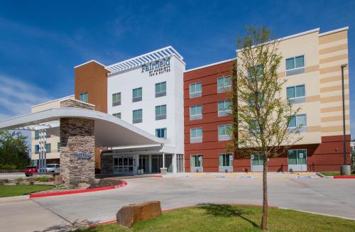 Exterior view of a modern hotel with a stone entrance and colorful facade under a clear blue sky.