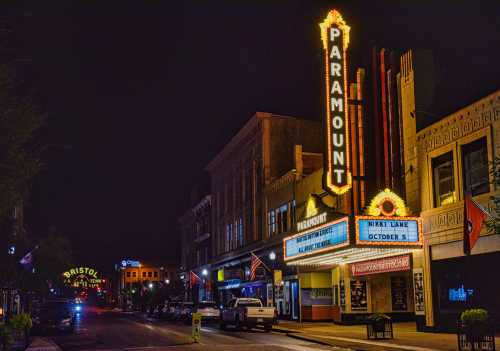 A brightly lit theater marquee at night, featuring "Paramount" and an event for Nikki Lane on October 5.