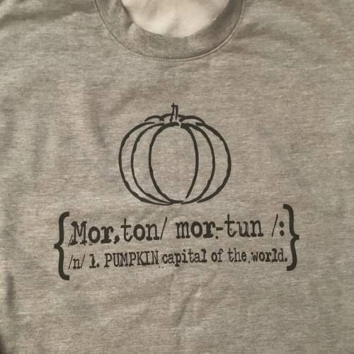 Gray t-shirt featuring a pumpkin graphic and text defining "Morton" as the "Pumpkin capital of the world."