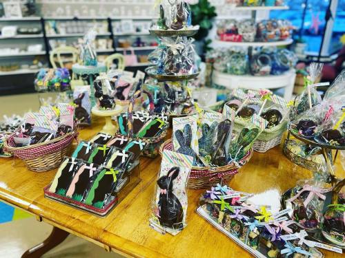 A colorful display of Easter chocolates and treats arranged on tables and shelves in a candy shop.
