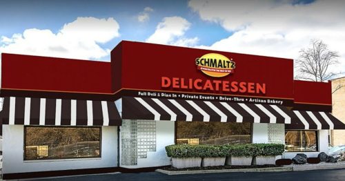 Exterior of Schmaltz Delicatessen featuring a red sign, striped awnings, and large windows.