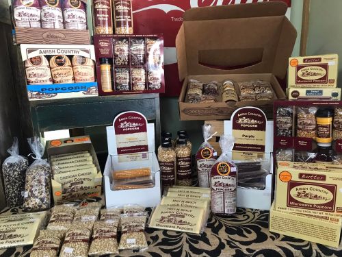 A display of various popcorn products, including bags, jars, and boxes, featuring different flavors and styles.