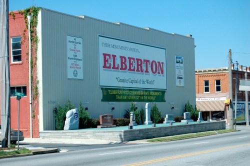 Sign for Elberton, "Granite Capital of the World," showcasing granite monuments and local businesses.