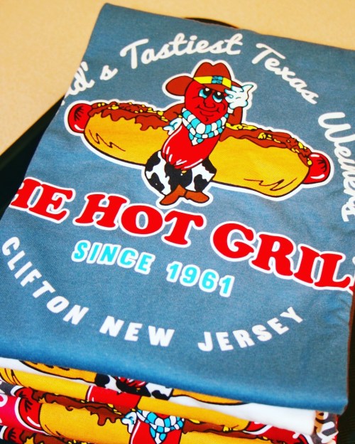 A colorful graphic of a hot dog mascot with text promoting "The Hot Grill" in Clifton, New Jersey, since 1961.
