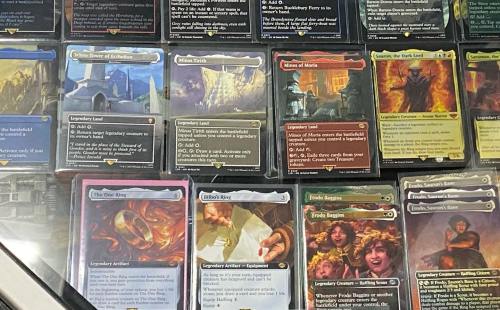 A collection of trading cards displayed in a case, featuring various fantasy-themed cards and characters.