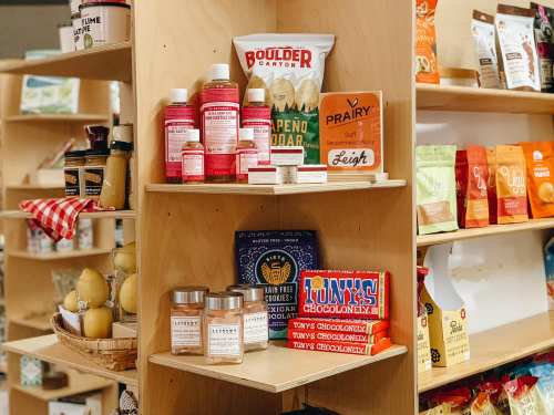 Shelves filled with various snacks and products, including chips, sauces, and chocolate bars.