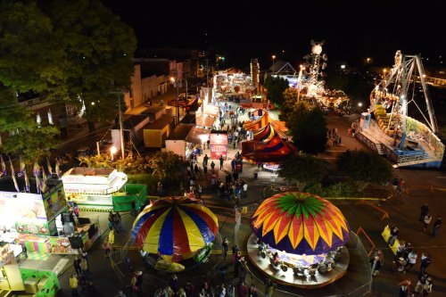 A vibrant night scene of a carnival with colorful rides, food stalls, and crowds enjoying the festivities.