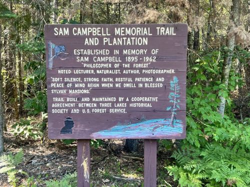 Sign for Sam Campbell Memorial Trail and Plantation, honoring the "Philosopher of the Forest" with a nature-themed design.