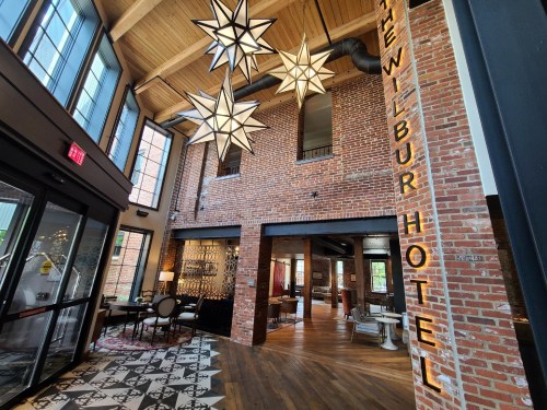 Interior of The Wilbur Hotel featuring exposed brick walls, star-shaped light fixtures, and a stylish seating area.