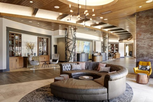 Modern hotel lobby featuring a circular leather sofa, stylish decor, and a welcoming reception area.
