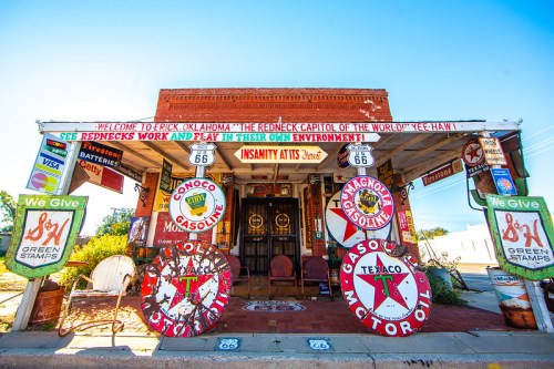 A colorful roadside store in Erick, Oklahoma, adorned with vintage gas station signs and Route 66 memorabilia.