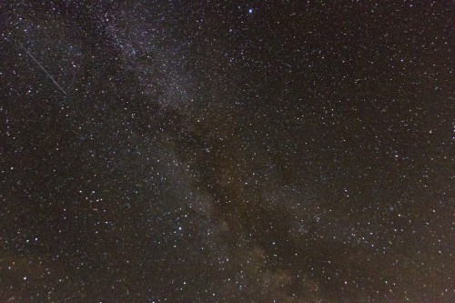 A stunning night sky filled with countless stars and a glimpse of the Milky Way galaxy.