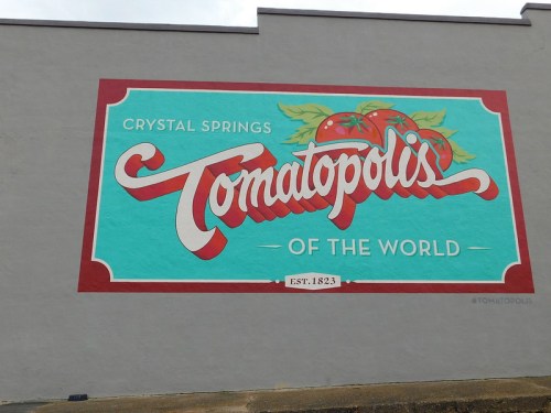 Colorful mural reading "Tomatopolis of the World" with tomatoes, located in Crystal Springs, established 1823.