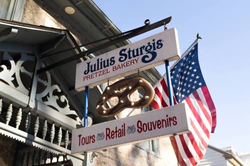 Sign for Julius Sturgis Pretzel Bakery with a pretzel graphic and an American flag in the background.