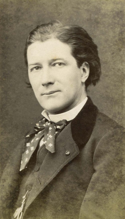 A vintage portrait of a young person with a bow tie and a serious expression, dressed in formal attire.