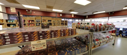 A store interior displaying shelves of assorted chocolates and gift baskets, with prices and labels visible.