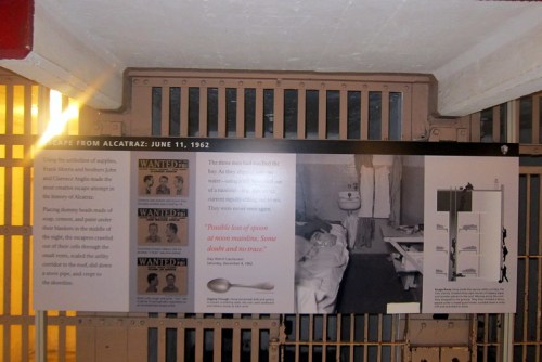 Sign about the Alcatraz escape on June 11, 1962, with images of wanted inmates and a view of a prison cell.