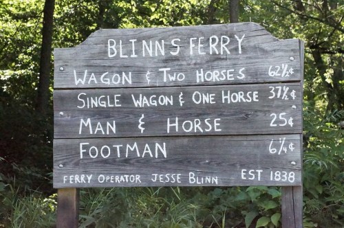 Sign for Blinn's Ferry listing prices for various transport options, including wagons and footman services. Established 1838.