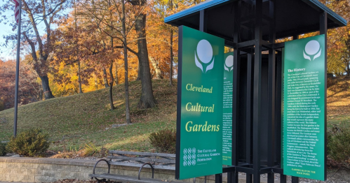 Signage at Cleveland Cultural Gardens, surrounded by autumn foliage, detailing the history of the gardens.
