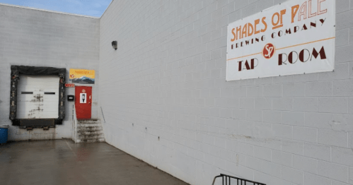 Exterior of Shades of Pale Brewing Company, featuring a loading dock and a sign for the tap room.